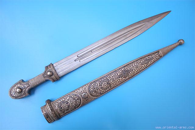 Caucasian qama or kindjal dagger, the 15cm pointed double edged blade with  centre fuller and two-piece horn grip; in nickel plated scabbard with  panels of figures and script L28.5cm overall; and east 